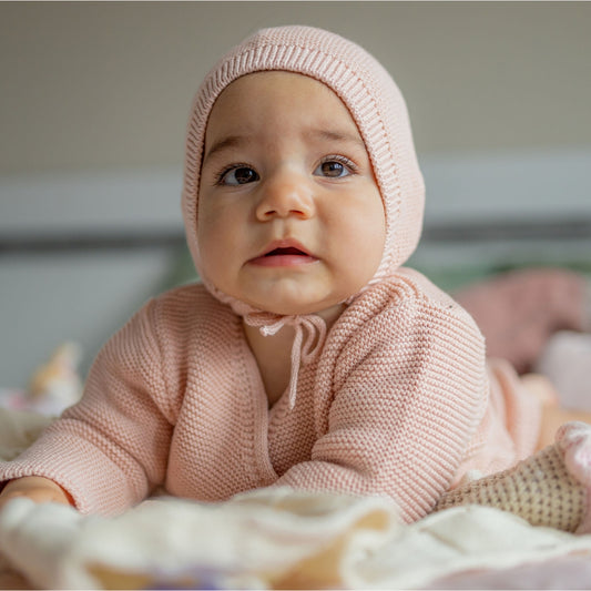 Knitted baby hat with garter stitch pattern, made from merino wool and organic cotton.